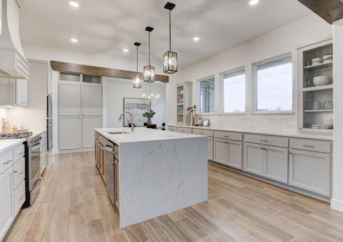Wide kitchen with soft grey painted cabinets and pendant lighting